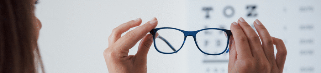 ragazza che guarda un paio di occhiali in un ostudio oculistico