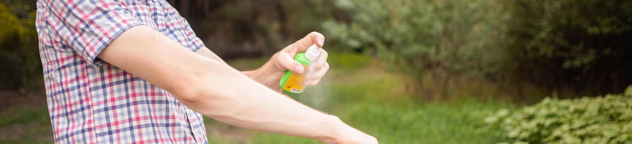 Ragazzo che spruzza sul braccio uno spray antizanzare